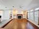 Open living room with fireplace, built-in shelves, wood floors and a view of the kitchen at 200 Patricia Pl, Davenport, FL 33897