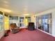 Bright sunroom with red carpet, two chairs, and plenty of natural light at 200 Patricia Pl, Davenport, FL 33897