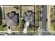 Aerial view of a house with a concrete driveway, a dark roof with solar panels and corner lot at 2005 Blackbird Dr, Apopka, FL 32703