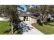 Aerial shot of a home with solar panels, a spacious driveway, and a well-manicured lawn at 2005 Blackbird Dr, Apopka, FL 32703