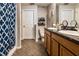 Well-lit bathroom featuring a double sink vanity with a granite countertop and a blue patterned shower curtain at 2005 Blackbird Dr, Apopka, FL 32703