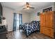 Comfortable bedroom featuring a plaid comforter, wooden floors, ceiling fan, and a wooden dresser at 2005 Blackbird Dr, Apopka, FL 32703