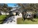 Charming home featuring solar panels and a long driveway surrounded by lush landscaping and mature trees at 2005 Blackbird Dr, Apopka, FL 32703