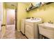 Laundry room with washer, dryer, utility sink, shelving, and a tiled floor at 2005 Blackbird Dr, Apopka, FL 32703