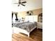 Bright bedroom featuring a large bed, wood-look floors, and a ceiling fan for comfort at 203 Flounder Pl, Kissimmee, FL 34759