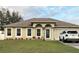 Charming single-story home with manicured lawn, arched entryway, and neutral color scheme with a newer car parked in the driveway at 203 Flounder Pl, Kissimmee, FL 34759