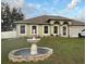 Inviting single-story home featuring a stone fountain and well-maintained landscaping with a newer car parked in the driveway at 203 Flounder Pl, Kissimmee, FL 34759