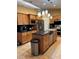 Well-appointed kitchen with stainless steel appliances, a functional island, and warm wood cabinetry at 203 Flounder Pl, Kissimmee, FL 34759