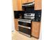 Gleaming stainless steel double oven with stovetop and range hood is nestled between stunning cabinets at 203 Flounder Pl, Kissimmee, FL 34759