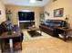 Inviting living room with tile floors, leather sofas, ceiling fan, and large television set for entertainment at 203 Flounder Pl, Kissimmee, FL 34759
