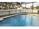 Screened-in pool with crystal clear water, surrounded by a deck and mature landscaping at 203 Flounder Pl, Kissimmee, FL 34759
