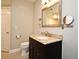 Bathroom featuring a dark wood vanity with a granite countertop, mirror, lighting and fixtures at 206 E South St # 1018, Orlando, FL 32801
