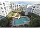 Aerial view of a refreshing pool surrounded by palm trees and a multi-story building at 206 E South St # 1018, Orlando, FL 32801