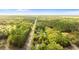 Scenic aerial view of property surrounded by trees along a quiet road at 20639 Sw Rainbow Lakes Blvd, Dunnellon, FL 34431