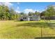 Backyard of the home with a partially fenced yard, plenty of open space, and trees at 20639 Sw Rainbow Lakes Blvd, Dunnellon, FL 34431