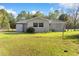 View of a backyard showcasing the home's exterior, a storage shed, and a fenced yard at 20639 Sw Rainbow Lakes Blvd, Dunnellon, FL 34431