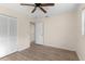 Bedroom with wood floors, ceiling fan, closet space, and access to another room at 20639 Sw Rainbow Lakes Blvd, Dunnellon, FL 34431