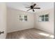 Bright bedroom featuring wood-look floors, a ceiling fan, and ample natural light from two windows at 20639 Sw Rainbow Lakes Blvd, Dunnellon, FL 34431