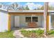 Close-up of a cozy front porch with a wooden swing, perfect for relaxing, complemented by fresh green plants at 20639 Sw Rainbow Lakes Blvd, Dunnellon, FL 34431