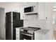 Kitchen featuring white marble-style backsplash, countertops, and modern stainless steel appliances at 20639 Sw Rainbow Lakes Blvd, Dunnellon, FL 34431