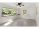 Living room offering tile flooring, a ceiling fan, multiple windows, and a convenient entrance at 20639 Sw Rainbow Lakes Blvd, Dunnellon, FL 34431