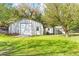 A metal outbuilding features a garage door, an additional shed, and a well-manicured lawn at 20639 Sw Rainbow Lakes Blvd, Dunnellon, FL 34431
