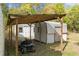 Lawnmower parked next to shed with covered storage area and additional shed in a grassy backyard at 20639 Sw Rainbow Lakes Blvd, Dunnellon, FL 34431