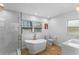 Bright bathroom with soaking tub, walk-in shower, and wood-look flooring at 212 Oakland Ave, Sanford, FL 32773