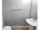 Compact half-bathroom with a white pedestal sink, toilet, and light gray walls at 2722 Dodds Ln, Kissimmee, FL 34743