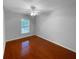 A spare bedroom with hardwood floors, a window, a ceiling fan, and light gray walls at 2722 Dodds Ln, Kissimmee, FL 34743