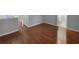 A hallway with hardwood floors leads to a spare bedroom and a bathroom at 2722 Dodds Ln, Kissimmee, FL 34743