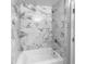 A shower featuring white marble-look tiling, a built-in shelf, and a bathtub at 2722 Dodds Ln, Kissimmee, FL 34743
