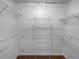A walk-in closet with a wooden floor and wire racks and shelves lining the walls at 2722 Dodds Ln, Kissimmee, FL 34743