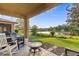 Relaxing backyard with a covered patio, lounge area, fire pit and lush landscaping, perfect for outdoor entertaining at 3320 Grande Heron Dr, Harmony, FL 34773