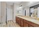 Bathroom featuring dual sinks, granite countertops, wood cabinets and a large mirror at 3320 Grande Heron Dr, Harmony, FL 34773