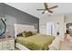 Comfortable bedroom with a ceiling fan, wood-look flooring, and soothing green bedding at 3320 Grande Heron Dr, Harmony, FL 34773