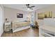 Cozy bedroom with wood floors, dresser, and a window providing natural light at 3320 Grande Heron Dr, Harmony, FL 34773