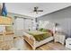 Comfortable bedroom with a ceiling fan, wood-look flooring, and soothing green bedding at 3320 Grande Heron Dr, Harmony, FL 34773