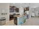 Well-equipped kitchen featuring dark cabinets, granite countertops, a central island, and stainless steel appliances at 3320 Grande Heron Dr, Harmony, FL 34773