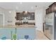 Modern kitchen featuring a kitchen island with a sink, dark cabinetry, and stainless steel appliances at 3320 Grande Heron Dr, Harmony, FL 34773