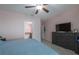 Comfortable bedroom with tiled floors, ceiling fan, dresser, and a view of the bathroom at 3797 Briarwood Estates Cir, St Cloud, FL 34772
