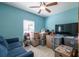 Bedroom with a blue sofa, stacked moving boxes, and a tv at 3797 Briarwood Estates Cir, St Cloud, FL 34772