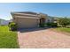 Well-maintained home with a two-car garage, brick driveway, and manicured landscaping at 3797 Briarwood Estates Cir, St Cloud, FL 34772