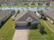 Aerial view of a cozy single-story home with a brick driveway and view of the backyard pond at 3797 Briarwood Estates Cir, St Cloud, FL 34772