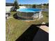 Outdoor view of a round pool with blue water in a green yard with white fencing and trees at 3797 Briarwood Estates Cir, St Cloud, FL 34772