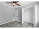 Neutral bedroom featuring wood-look floors, ceiling fan, and closet with white trim at 509 Nicole Blvd, Ocoee, FL 34761