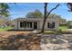 Charming single-story home with black trim, front yard with mature trees, and a welcoming entrance at 509 Nicole Blvd, Ocoee, FL 34761