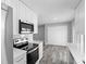 Well-lit kitchen boasting stainless steel appliances, white cabinetry, and views to the backyard at 509 Nicole Blvd, Ocoee, FL 34761