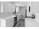Modern kitchen featuring sleek white cabinetry, stainless steel appliances, and stylish gray wood flooring at 509 Nicole Blvd, Ocoee, FL 34761