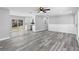 Open-concept living room with gray vinyl floors, white walls and trim, ceiling fan, and modern fixtures at 509 Nicole Blvd, Ocoee, FL 34761
